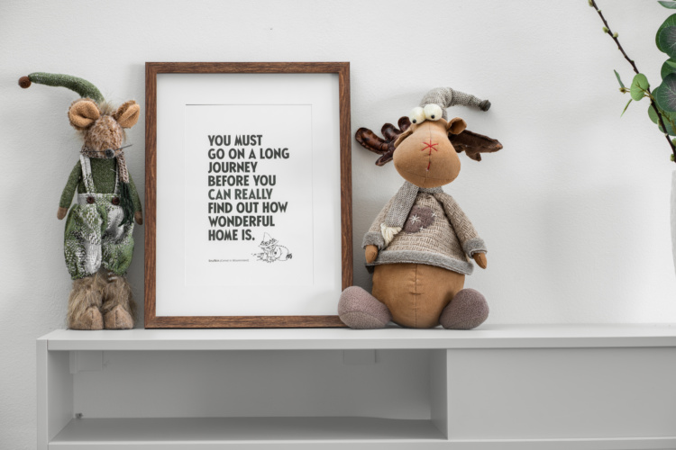 Dos figuras de animales de tela y una frase enmarcada sobre una repisa blanca